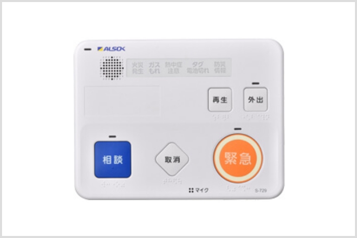 壁に設置するタイプの長方形の機器。色は白。大きめのボタンがいくつかついていて、「相談」や「緊急」と書かれている。
										