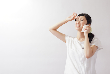 ハンカチで汗を拭く女性
