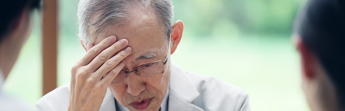 頭を抱える老人男性